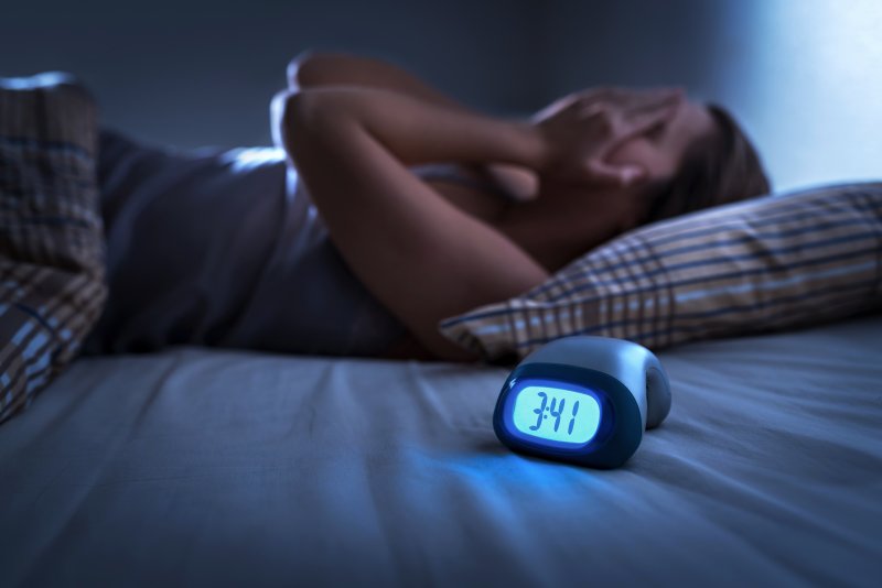 Woman with sleep apnea awake in bed at night