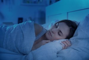 Woman in bed, possibly after using at-home sleep apnea test