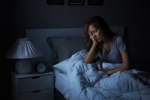 a woman struggling to stay asleep at night 